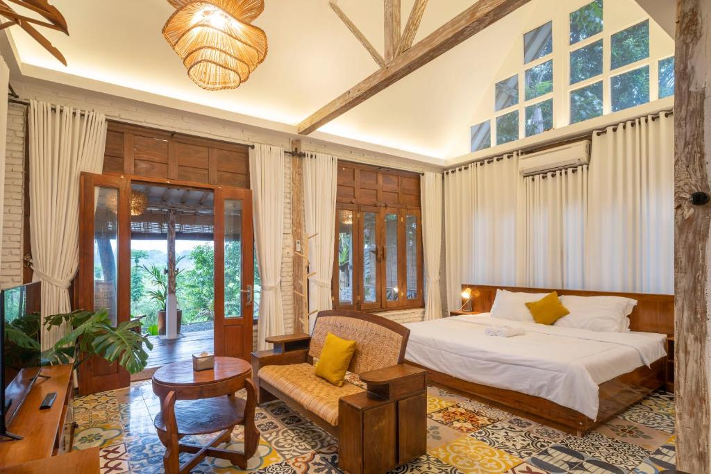 Kamar unit Sare 03 SARÉ Bangunjiwo dengan langit-langit tinggi dan jendela kayu