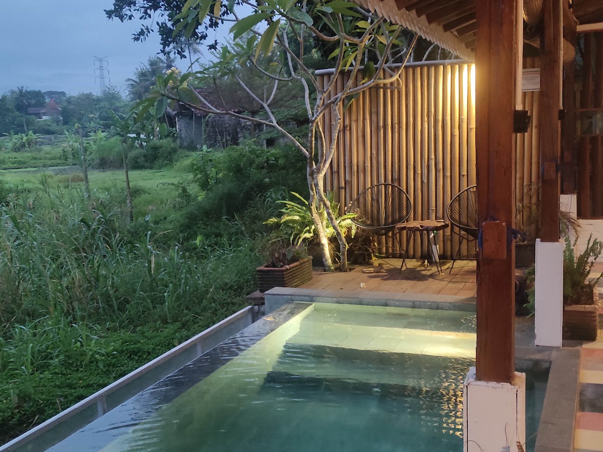 Kolam privat dan teras SARÉ menghadap sawah saat senja